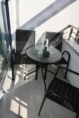 a table with two glasses of wine on a balcony at Orzeja apartments in Ulcinj