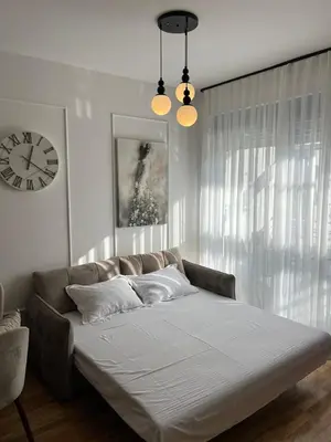 a bed in a room with a clock on the wall at Orzeja apartments in Ulcinj