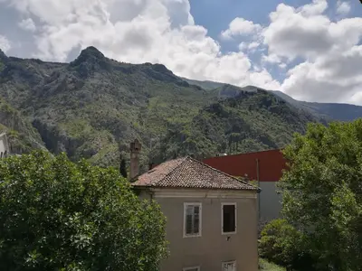 a building with a mountain in the background at Apartment Nikolic Kotor in Kotor