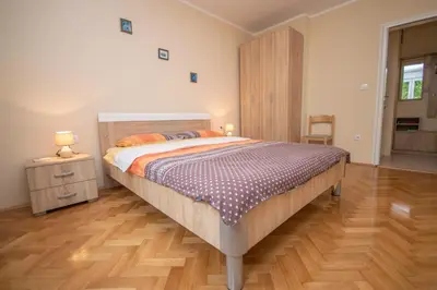 a bedroom with a large bed and a wooden floor at Apartment Nikolic Kotor in Kotor