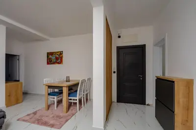 a dining room with a table and a black door at Aurora Apartments in Bar