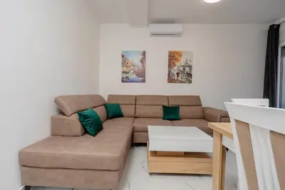 a living room with a brown couch and a table at Aurora Apartments in Bar