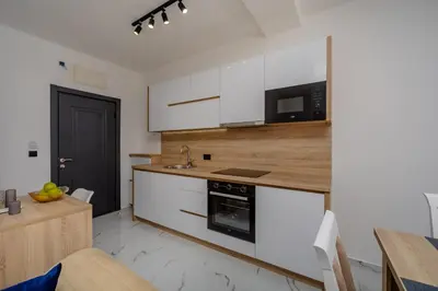 a kitchen with white cabinets and a counter top at Aurora Apartments in Bar