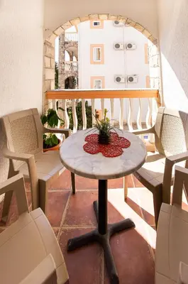 a small table on a balcony with chairs at Villa Iper in Budva