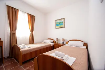 a hotel room with two beds and a window at Villa Iper in Budva