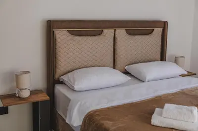 a bed with two white pillows and a headboard at B&O Seaview in Bar