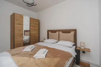 a bedroom with a large bed with two towels on it at B&O Seaview in Bar