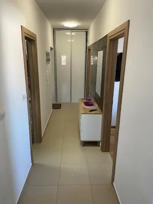 a hallway of a bathroom with a sink and a mirror at Apartment with large living room in Bar
