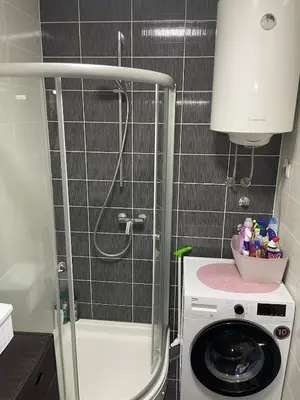 a small bathroom with a washing machine and a washer at Apartment with large living room in Bar