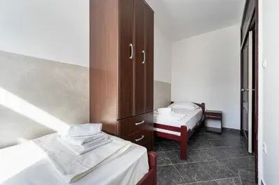 a small room with two beds and a cabinet at Delfin Apartments in Sutomore