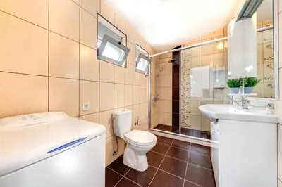 a bathroom with a toilet and a sink at Delfin Apartments in Sutomore