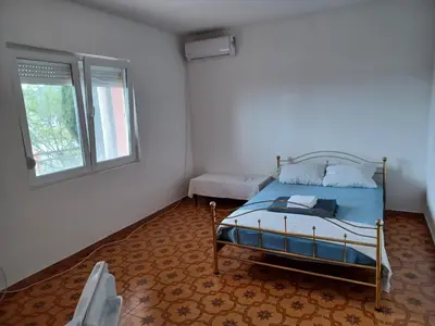 a bedroom with a bed and a window at Pink Holiday House Sutomore in Zankovići