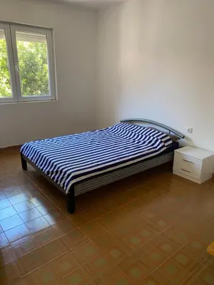 a bed in a white room with a window at Pink Holiday House Sutomore in Zankovići