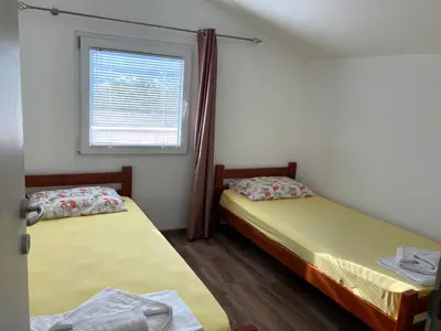 two beds in a room with a window at Mystras Apartments in Kotor