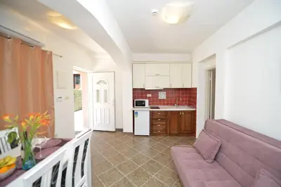 a living room with a couch and a kitchen at Mystras Apartments in Kotor