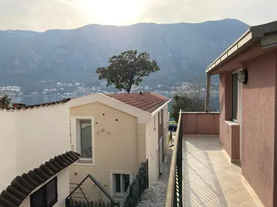a view of a house with mountains in the background at Mystras Apartments in Kotor