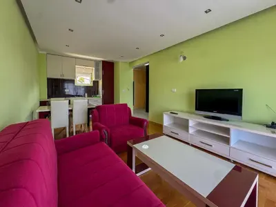 a living room with pink furniture and a flat screen tv at One-bedroom Apart, with panoramic view, Prijevor in Prijevor