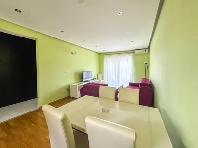a room with a table and chairs and a television at One-bedroom Apart, with panoramic view, Prijevor in Prijevor