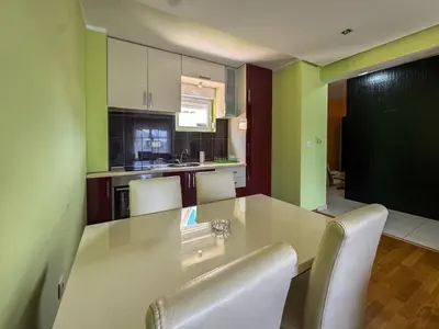 a kitchen with a table and white chairs in it at One-bedroom Apart, with panoramic view, Prijevor in Prijevor