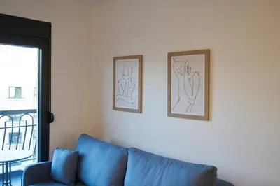 a blue couch in a living room with two pictures on the wall at Montenegro Luxury Studio - Hill Homes in Podgorica