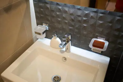a bathroom sink with a soap dispenser on it at Montenegro Luxury Studio - Hill Homes in Podgorica