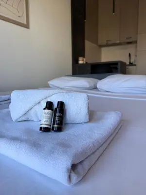 two bottles of shampoo and towels on a bed at Montenegro Luxury Studio - Hill Homes in Podgorica