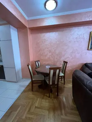 a dining room with a table and chairs and a couch at Apartman Marina in Podgorica