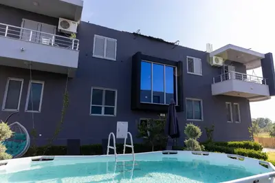 a house with a swimming pool in front of a building at Sunshine Apartments in Ulcinj