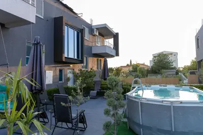a patio with a hot tub next to a building at Sunshine Apartments in Ulcinj