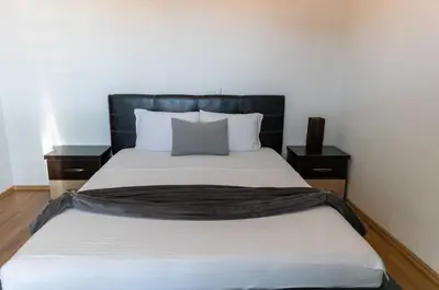 a bed with a black headboard in a room at Sunshine Apartments in Ulcinj