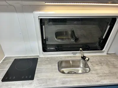 a kitchen counter with a sink and a microwave at Eagle's path campers Montenegro in Podgorica