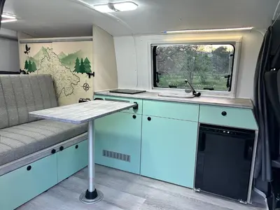 a kitchen with blue cabinets and a sink and a window at Eagle's path campers Montenegro in Podgorica