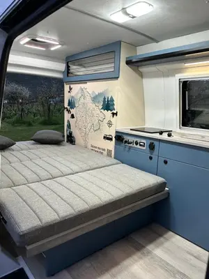 a small bedroom with a bed and a kitchen at Eagle's path campers Montenegro in Podgorica