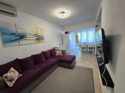 a living room with a purple couch and a table at Cozy apartment in Petrovac in Petrovac na Moru