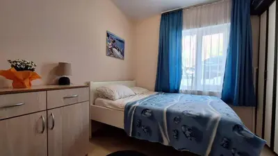 a bedroom with a bed and a window with blue curtains at Cozy apartment in Petrovac in Petrovac na Moru