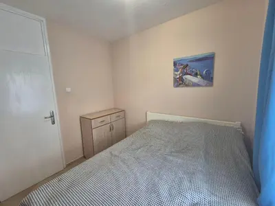 a bedroom with a bed and a painting on the wall at Cozy apartment in Petrovac in Petrovac na Moru