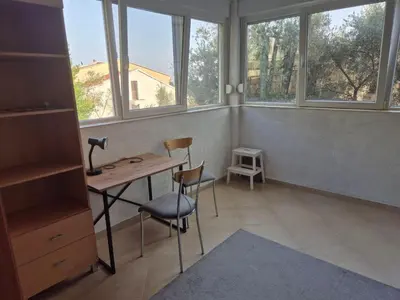 a room with a desk and chairs and windows at Cozy apartment in Petrovac in Petrovac na Moru