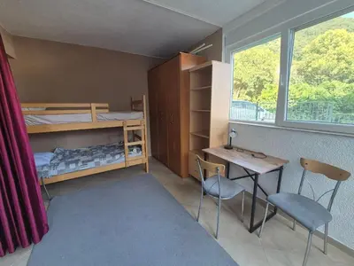 a room with a bunk bed and a table and chairs at Cozy apartment in Petrovac in Petrovac na Moru