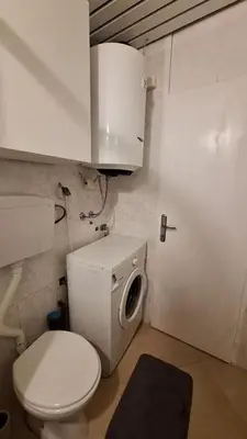 a small bathroom with a toilet and a sink at Cozy apartment in Petrovac in Petrovac na Moru
