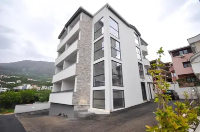 a white apartment building with a large window at Studio Dobra Voda 4 in Dobra Voda