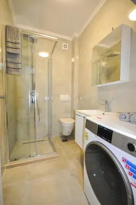 a bathroom with a shower and a washing machine at Studio Dobra Voda 4 in Dobra Voda