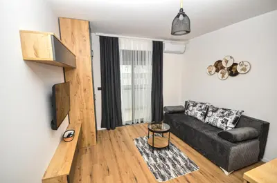 a living room with a couch and a stair case at Studio Dobra Voda 4 in Dobra Voda