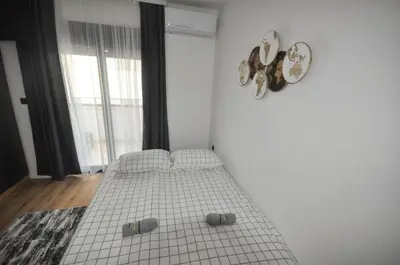 a bedroom with a bed in a white room at Studio Dobra Voda 4 in Dobra Voda
