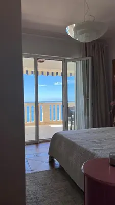 a bedroom with a bed and a view of the ocean at Beachfront Four Bedroom Apartment in Sveti Stefan
