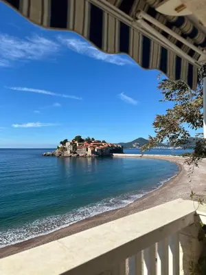 a view of a beach with a house on the shore at Beachfront Four Bedroom Apartment in Sveti Stefan