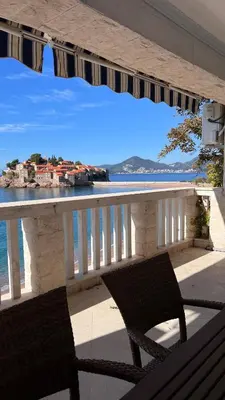 a balcony with two chairs and a view of the ocean at Beachfront Four Bedroom Apartment in Sveti Stefan