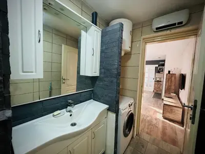 a bathroom with a sink and a washing machine at Svetli dom in Sutomore