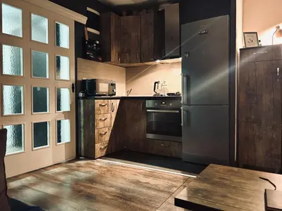 a kitchen with a stainless steel refrigerator and wooden cabinets at Svetli dom in Sutomore