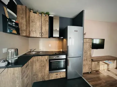 a kitchen with wooden cabinets and a stainless steel refrigerator at Svetli dom in Sutomore