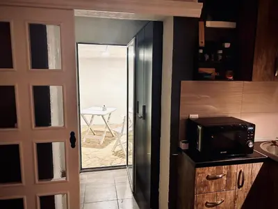 a kitchen with a door leading to a patio with a table at Svetli dom in Sutomore